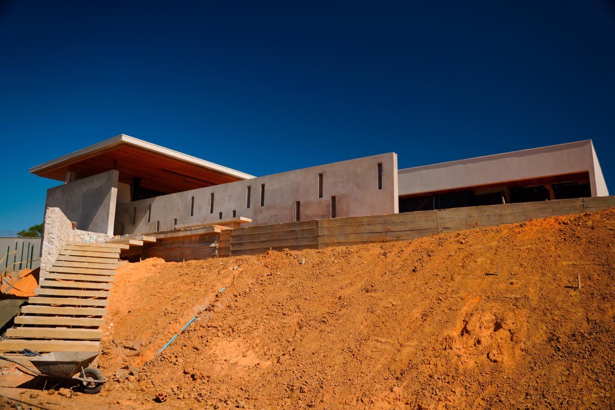 Engenheiro e arquiteto revisando projeto de casa de alto padrão em obra da EZA Engenharia em Criciúma