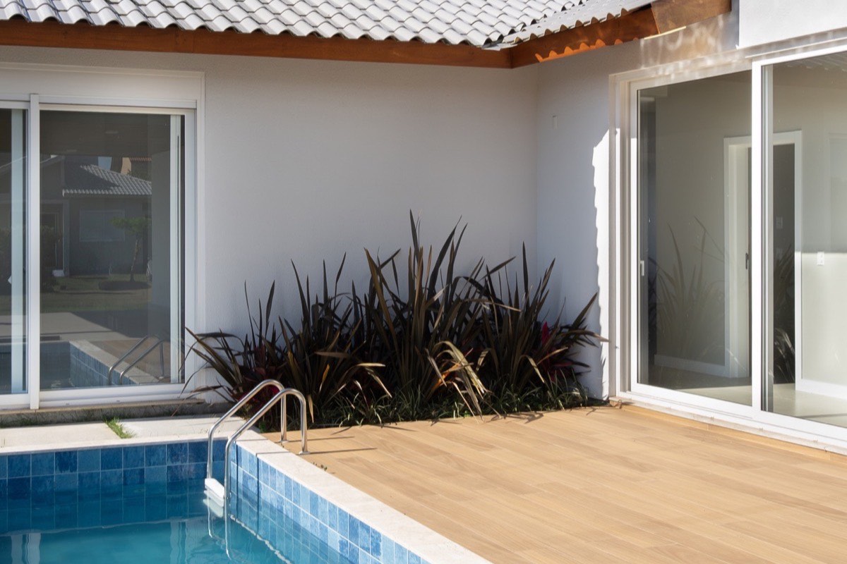 Escada residencial em concreto com guarda-corpo de vidro em casa de alto padrão construída pela EZA Engenharia em Criciúma